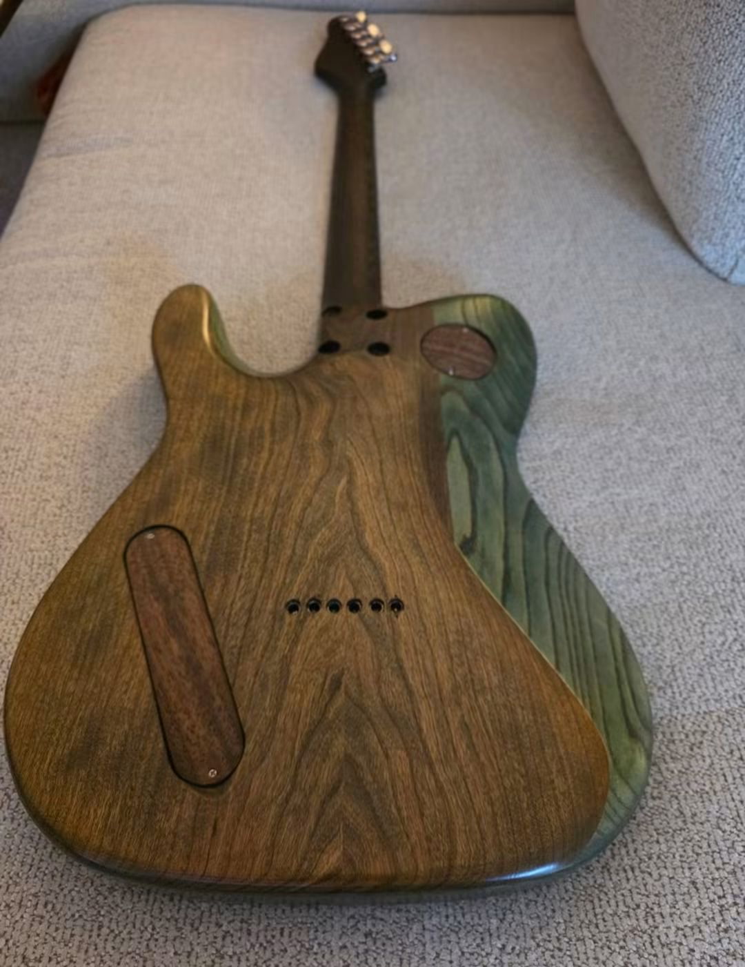 Natural wood back of a guitar with fitted wooden cavity covers